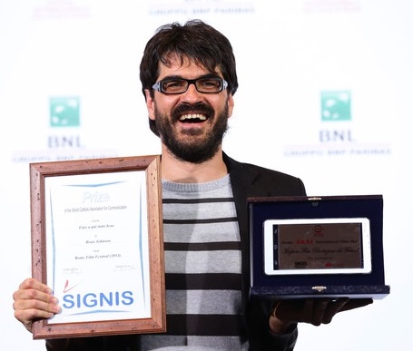 Director Roan Johnson smiling and holding an award in his hands.